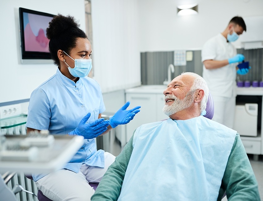 An older man talks to his dentist